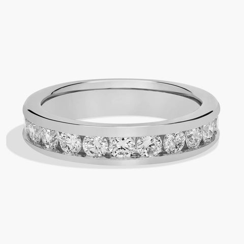 Channel-set round diamond eternity band in 14K white gold, shown on hand and isolated.
