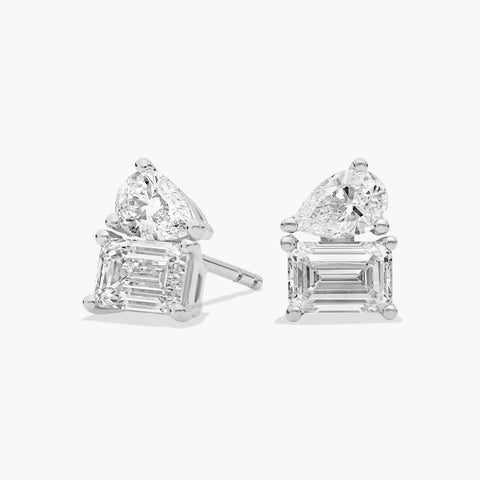 14K white gold emerald and pear cut diamond stud earrings with secure push-back closures on a white background.

