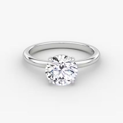 Close-up view of a round brilliant cut solitaire diamond ring in solid 14K white gold with a sleek minimalist band.